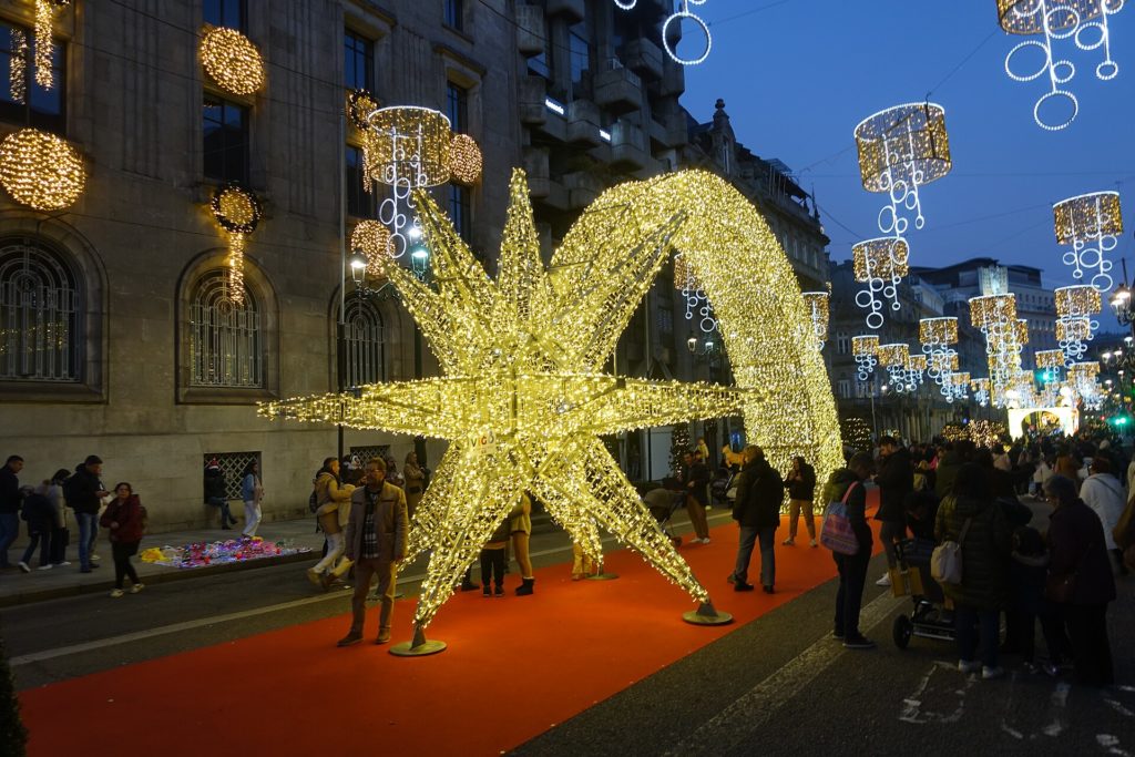 Gente paseando junto a la estrella gigante de las luces de Navidad de Vigo