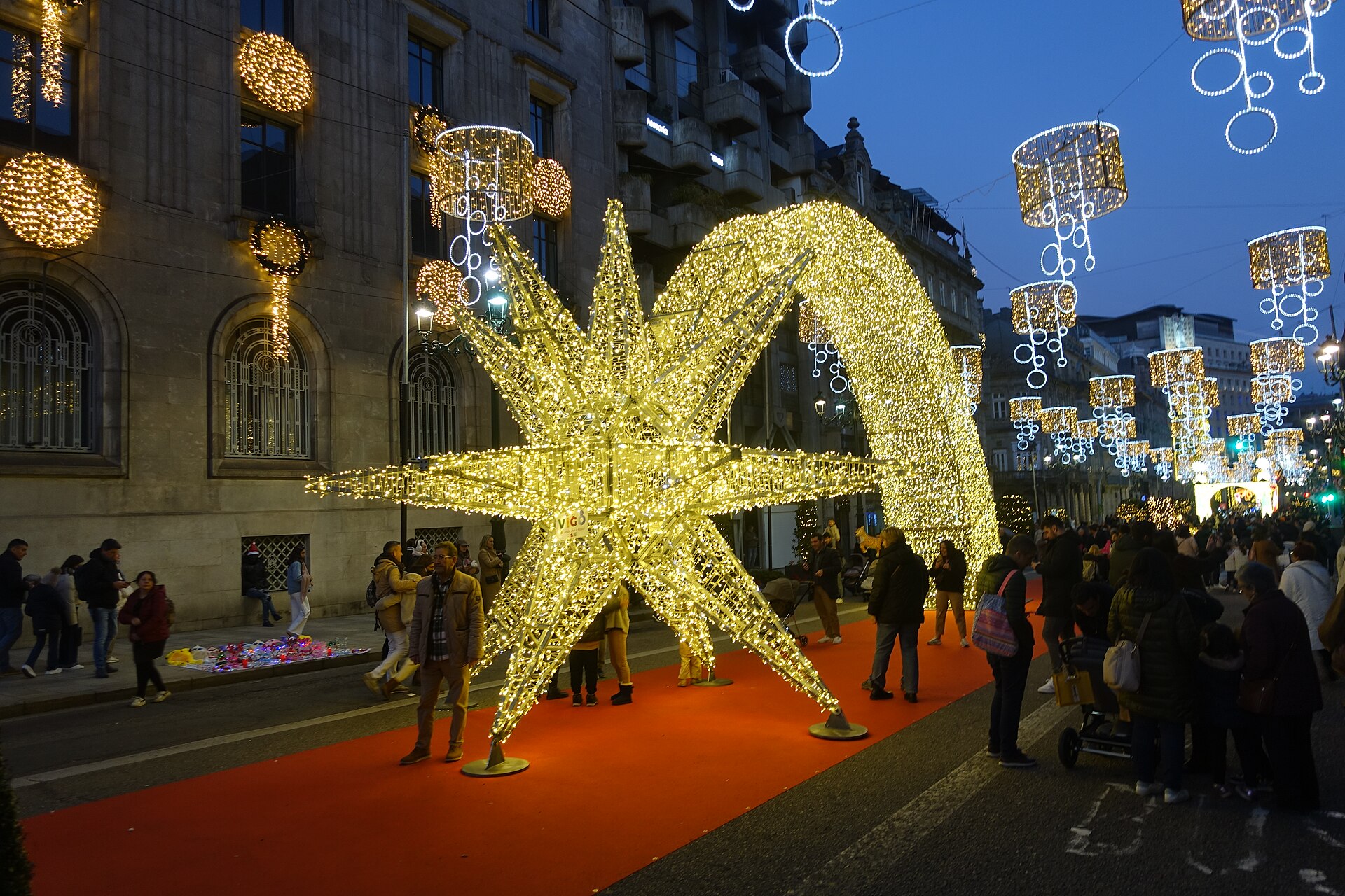 Gente paseando junto a la estrella gigante de las luces de Navidad de Vigo